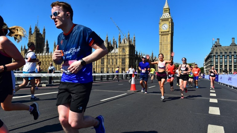 A picture of me (Luc Shelton) in a SpecialEffect athletic jersey running across London Bridge. Behind me is the Palace of Westminster and Big Ben.
